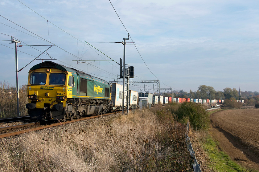 66537, 09.12 Felixstowe-North Ditton (4M63), Wilsons Crossing 
 The 4M63 09.12 Felixstowe to Ditton Freightliner takes the up grade past Wilson's Crossing near Northampton. In the background the spire of Kingsthorpe Village's St. John the Baptist's church. The field to the right may well be sown with its last ever crop as permission had just been granted for a huge house development to cover it and the surrounding area. 
 Keywords: 66537 09.12 Felixstowe-North Ditton 4M63 Wilson's Crossing