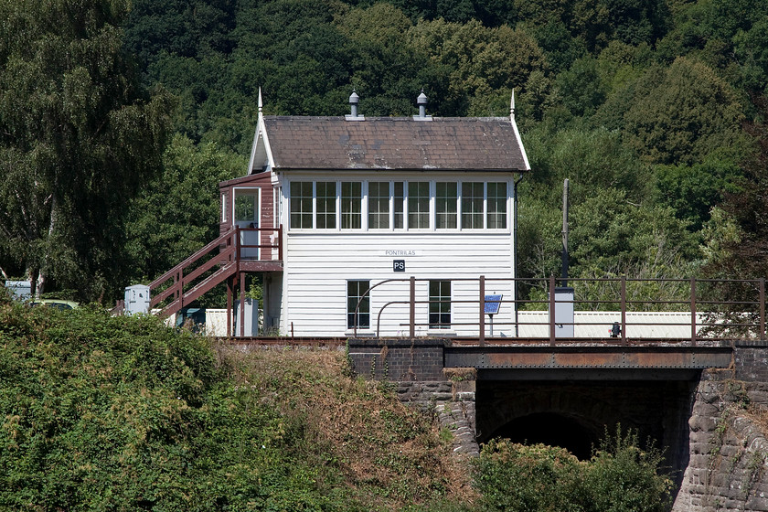 Pontrilas signal box (GWR, 1880) 
 A picture that necessitated a walk up a path into a field a fair way from the box and then the use of the zoom at its full focal length. Pontilas signal box is delightful GW Type 3 box constructed in 1880. The steps and porch are later additions. Even though this looks to be a rural location, looks can be deceiving as it's in a busy village with a very active timber mill not far to the right. 
 Keywords: Pontrilas signal box