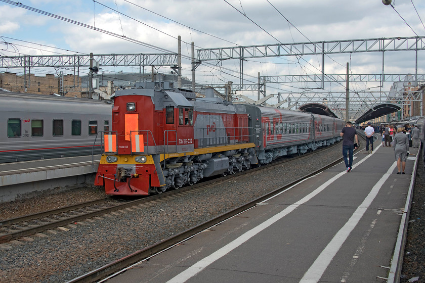 TZM18V-052, station pilot, St. Petersburg Moskovski station 
 Station pilot TZM18V-052 removes the stock from an earlier arrival at St. Petersburg Moskovski station. I have not over processed this image in Photoshop, the under frames of both the stock and the locomotive are painted this universal grey colour. I am not sure if this paint had recently been applied but it did look very fresh. Having said this, all the trains I observed in Russia, with the possible exception of some of the Moscow suburban stock, was very clean and well maintained. 
 Keywords: TZM18V-052 St. Petersburg Moskovski station