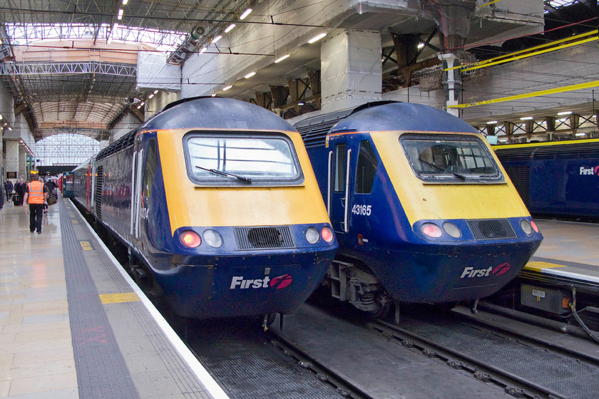 43124, GW 09.53 London Paddington-Old Oak Common HST depot ECS (5L28) & 43165, GW 09.45 London Paddington-Swansea (1B20), London Paddington station 
 With continuing evidence of extensive works taking place at Paddington station two HSTs sit at the blocks as awaiting their next moves with a third off to the right. 43124 will soon leave heading to Old Oak Common as the 5L28 empty coaching stock working. Next to it 43165 'Prince Michael of Kent' will leave at the rear of the 1B20 09.45 to Swansea. The former power car entered service in June 1981 as a spare power car never assigned to a set. The later was one of the fourth batch of HSTs delivered in September 1981 as part of set 253042 initially working on the north-east to south-west route. 
 Keywords: 43124 09.53 London Paddington-Old Oak Common HST depot ECS 5L28 43165 09.45 London Paddington-Swansea 1B20 London Paddington station First Great Western Prince Michael of Kent