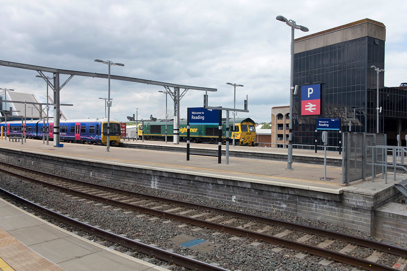 165111, 12.12 London Paddington-Reading (2R35) & 66566, 10.58 Bristol FLT-Tilbury (4L32), Reading station 
 The vast and somewhat featureless expanse to the eastern end of Reading's re-built station with the electrification structures going in. To the left, 165111 has just arrived with the 12.12 from Paddington whilst 66566 passes through the station leading the daily 4L42 10.58 Bristol FLT to Tilbury Freightliner working. 
 Keywords: 165111 12.12 London Paddington-Reading 2R35 66566 10.58 Bristol FLT-Tilbury 4L32 Reading station