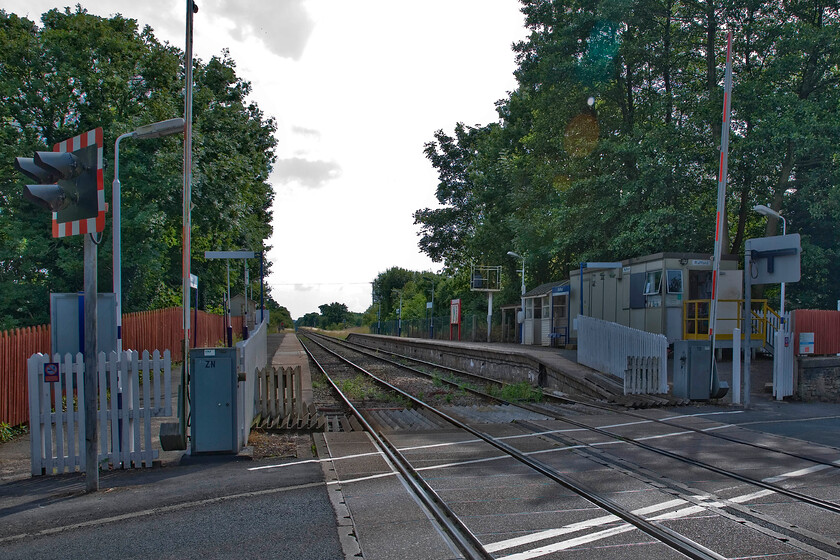 Rufford station, level crossing & signal box box (BR, 1988) 
 When I last visited Rufford in April 1986 the level crossing and signalling were controlled by a superb Lancashire and Yorkshire Type 7 box located directly behind where I am standing. Over many years the line from Merseyside to Preston was progressively run down and singled with Rufford becoming the only intermediate box that controlled a passing loop seen in this image. Further rationalisation came for Rufford in 1988 when the Portacabin structure, seen on the down platform, was built and commissioned replacing the L & Y box. Rather than bells and levers the new 'box' contained a handful of switches to control the revised layout. 
 Keywords: Rufford station, level crossing & signal box box BR 1988