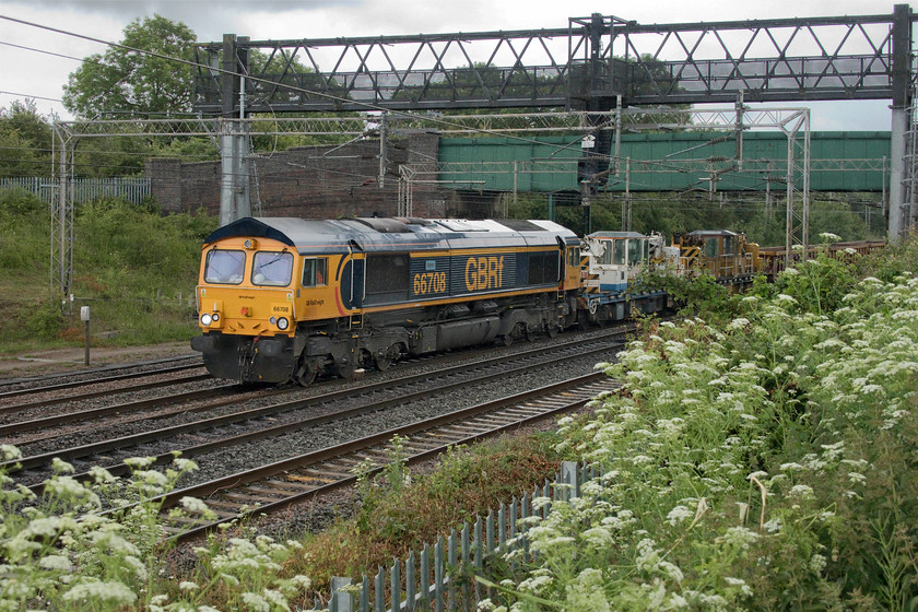 66708, 10.00 Willesden West London Junction-Bescot up engineers (7G52, 2L), Gordon`s Lodge 
 In the pouring rain of a June afternoon, 66708 'Jayne' plods its way past Gordon's Lodge between Wolverton and Northampton leading the 10.00 Willesden to Bescot engineering train. Behind the two mini cranes is a long rake of JNA wagons. The last time that I saw 66708 it was just as dull as it is on this day but at least it was not raining, see...... https://www.ontheupfast.com/p/21936chg/27343880004/x66708-15-28-scunthorpe-roxby-gullet 
 Keywords: 66708 10.00 Willesden West London Junction-Bescot up engineers 7G52 Gordon`s Lodge GBRf GB Railfreight Jayne