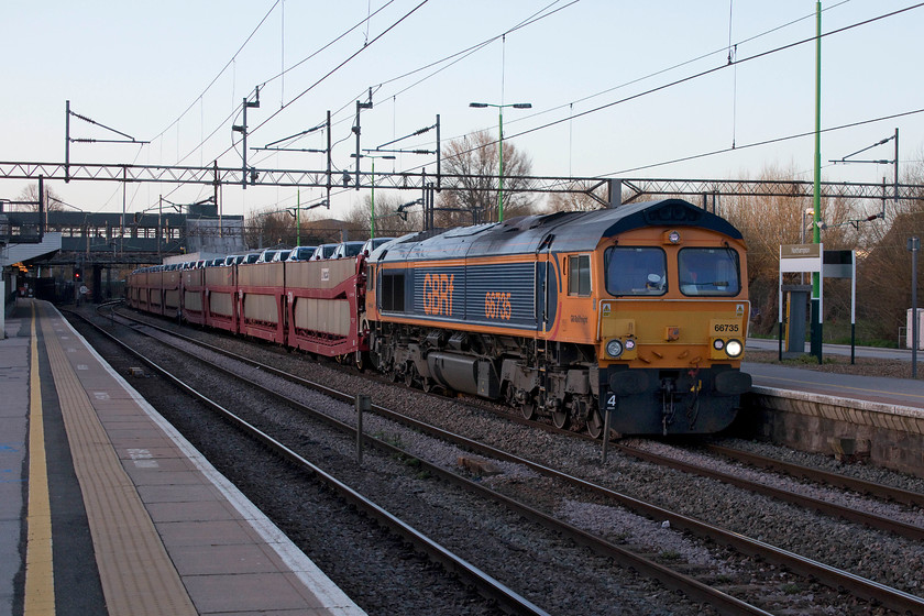 66735, 03.30 Dagenham-Garston (6X41), Northampton station 
 In the half light at Northampton station, 66735 brings the 03.30 Dagenham to Garston cartic train slowly through the station. This was along train full of 'Dagenham Dustbins' ranging from a tiny Ka to the larger Transit and in all colours imaginable! 
 Keywords: 66735 03.30 Dagenham-Garston 6X41 Northampton station