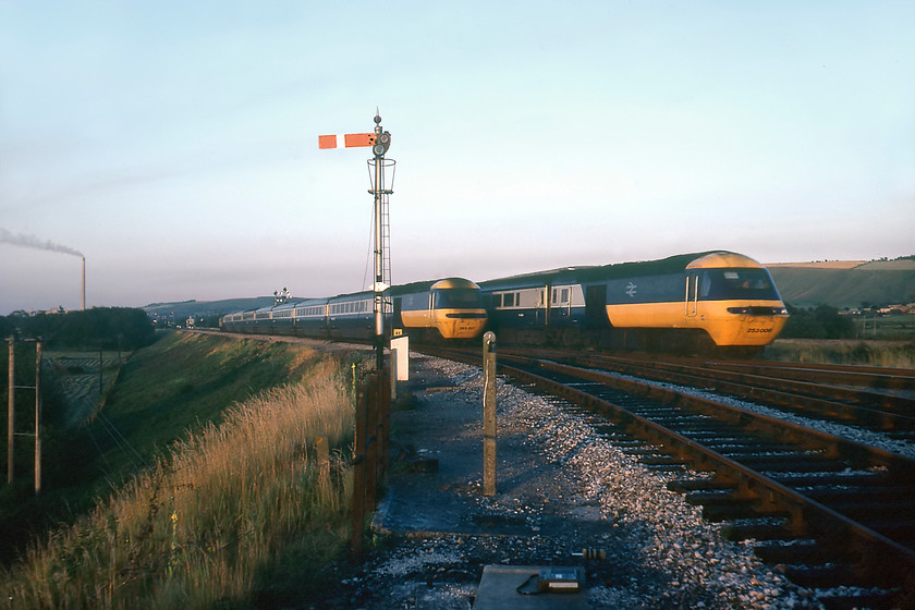 253008, 19.25 London Paddington-Plymouth & 253017, 16.23 Penzance-London Paddington, Hawkeridge East Junction 
 Two HSTs in their 'as-built' liveries pass each other at Hawkeridge East Junction near Westbury. With Westbury cement works to the left and the down starter off the Hawkeridge chord in the foreground, 253017 slows for its Westbury stop forming the 19.25 Paddington to Plymouth service. Meanwhile, 253017 accelerates away east with the 16.23 Penzance to Paddington. Despite our somewhat exposed position, we did not encounter any problems with staff and officials, indeed, the signalman at Heywood Road, a little after this photograph was taken, did not mind us trackside taking photographs in the dying summer light. 
 Keywords: 253008 19.25 London Paddington-Plymouth 253017 16.23 Penzance-London Paddington, Hawkeridge East Junction HST Westbury 43016 43017 43034 43035