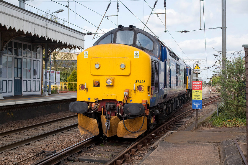 37425 & 57301, Norwich-Willesden LEs, Diss station 
 On arrival at Diss station Andy and I became aware of an interesting train approaching in the distance. Initially, all we could see was a large slab of yellow on the long straight north of the station, however, as it got closer we realised it was class 37. 37425 and 57301 'Scott Tracy' pass through Diss forming an unidentified Norwich Crown Point to Willesden light engine move, regrettably, we did not get a reporting number for this train, if anybody has any details at all we would be grateful!. 
 Keywords: 37425 57301 Diss station