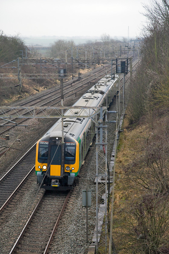 350250, LN 10.46 London Euston-Crewe (1U31, 5L), Victoria Bridge 
 350250 takes the down fast line past Victoria Bridge with the 10.46 London Euston to Crewe. This service runs 'fast' as far as Staffordshire then, essentially, becomes a 'slow' stopper. It always strikes me as strange service pattern? 
 Keywords: 350250 10.46 London Euston-Crewe 1U31 Victoria Bridge