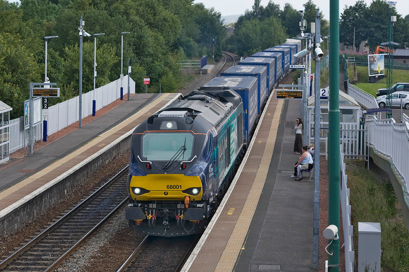 68001, 12.23 Grangemouth Tdg Sidings-Aberdeen Craiginches (4A13), Camelon station 
 68001 'Evolution' accelerates its way noisily through Camelon station leading the 4A13 12.23 Grangemouth to Aberdeen intermodal working. It would have been all too easy for these boxes have to made the relatively short journey by truck causing even greater congestion on the M90 motorway and A90 trunk road but the DRS flow avoids this and must be the way to go for the future of freight. 
 Keywords: 68001 12.23 Grangemouth Tdg Sidings-Aberdeen Craiginches 4A13 Camelon station DRS Intermodal Evolution