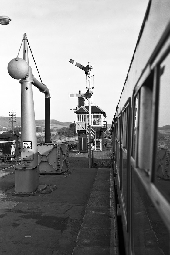 Battersby signal box (NER, 1901) & NER water column 
 Leaving Battersby station aboard the 10.14 Whitby to Middlesborough service being worked by Class 101 DMU formed by E50248 and E50543 we pass a scene that is a delight to the railway modeller! The former NER water column dating from 1907 still stands today, see.... https://www.ontheupfast.com/p/21936chg/26273784404/water-column-battersby-station but everything else seen here has been wiped away in the name of progress. Notice the driver leaning out of his cab ready to accept the token from the signalman giving him the authority to progress to Nunthorpe 
 Keywords: Battersby signal box NER water column North Eastern Railway