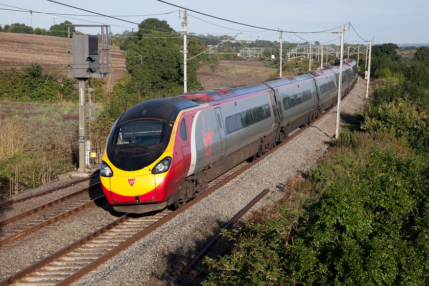 390130, VT 06.35 Manchester Piccadilly-London Euston (1A06, 1L), Milton Crossing 
 With the driver adjusting his sun visor, 390130 'City of Edinburgh' passes Milton Crossing just south of Blisworth on the Weedon loop working the 06.35 Manchester Piccadilly to London Euston. 
 Keywords: 390130 VT 06.35 Manchester Piccadilly-London Euston 1A06 Milton Crossing