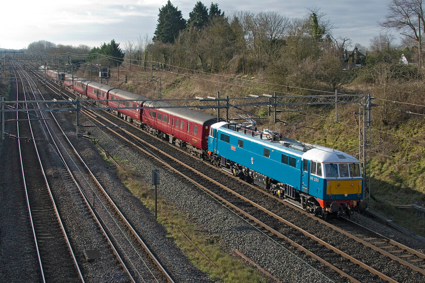 86259, outward leg of The Winter Cumbrian Mountain Express, 06.35 London Euston-Carlisle (1Z86, 17L), Victoria bridge 
 Running over thirty minutes late after leaving Euston some fifteen minutes adrift I did wonder in 86259 'Les Ross/Peter Pan' had once again developed a mechanical problem of some kind. However, it appears not as the locomotive and stock made it all the way to Carnforth but still considerably behind schedule. The AL6 looks good in the morning sunshine passing Victoria bridge near the Northamptonshire village of Ashton leading the 1Z86 06.35 Euston to Carlisle Winter Cumbrian Mountain Express charter. Due to its late running there were a number of Avanti Pendolinos stacked up behind it all running on caution that makes me wonder why signallers did not path the charter through Northampton. 
 Keywords: 86259 The Winter Cumbrian Mountain Express 06.35 London Euston-Carlisle 1Z86, Victoria bridge Less Ross Peter Pan AL6