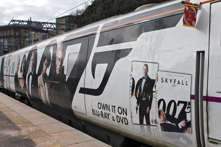 Graphics, 82231, GR 17.00 Edinburgh Waverley-London King's Cross, Edinburgh Waverley station 
 IC225 set BN29 has been entirely re-vinyled in a tie-up between East Coast (under the stewardship of Karen Boswell) and the producers of the twenty-third Bond film Skyfall. In recent years it appears that the railways, and the trains in particular, have become a useful advertising medium for the film industry with exercises such as this becoming more common; it certainly makes for a more interesting scene! 
 Keywords: Graphics 82231 17.00 Edinburgh Waverley-London King's Cross Edinburgh Waverley station James Bond Skyfall