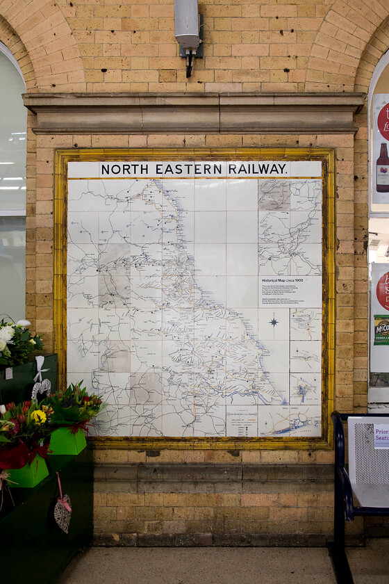 NER tiled route map (c.1900), York station 
 With the adjacent florist's display to the left one of the remaining former North Eastern Railway's tiled maps is seen at York station. Composed of sixty-four square white glazed ceramic tiles with a border of forty-eight moulded capping tiles they are still to be found at a number of stations throughout the northeast. They were manufactured by Craven, Dunnill & Co Ltd, and were installed in and around 1900 with nine remaining examples at Beverley, Hartlepool, Middlesbrough, Morpeth, Saltburn, Scarborough, Tynemouth, Whitby and here at York. 
 Keywords: NER tiled route map York station