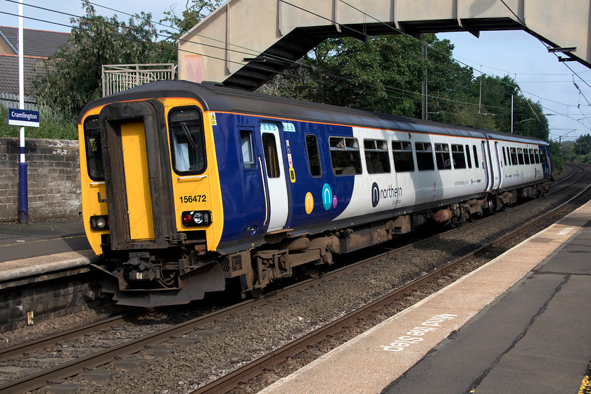 156472, NT 09.19 Newcastle-Morpeth (2A02, 1L), Cramlington station 
 156472 leaves Cramlington station with the Sunday morning 09.19 Newcastle to Morpeth service. Notice the steeply cambered track, non-stopping services take full advantage of this passing through at quite a speed! There is talk of the station moving a short distance south of its present location to a far better-suited site for the New Town residents of Cramlington this to better serve employment areas and shoppers. A larger car park and rail-bus interchange could also be constructed. 
 Keywords: 156472 09.19 Newcastle-Morpeth 2A02 Cramlington station