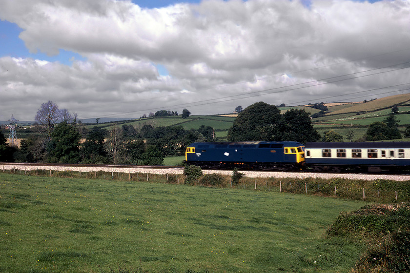 47252, 08.00 Bristol Temple Meads-Plymouth, Lillisford Farm SX823647 
 47252 descends Dainton towards Totnes leading the 08.00 Bristol to Plymouth (SUo) service. The train is seen in the early morning Sunday sunshine passing where we had spent the night 'rough camping' (with the permission fo the farmer) close to Lillisford farm. As 47747, the loco. survived into the privatisation era becoming an EWS liveried machine and then to Riviera Trains. It was stored for many years being cut up in 2013 by Booths. 
 Keywords: 47252 08.00 Bristol Temple Meads-Plymouth Lillisford Farm SX823647