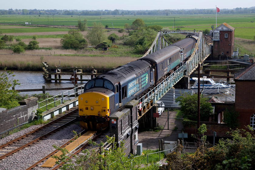 37405 & 37407, LE 15.48 Lowestoft-Norwich (2J83, 1E), Reedham Swing Bridge 
 When the re-signalling of the Wherry Lines is completed during the spring of 2019, it is likely that this will be the only 'signal' box that will remain in use. Whilst technically it controls the swing bridge and associated signals Network Rail have not been able to identify a suitable way to automate the opening and closing of the Reedham swing bridge. So, for the foreseeable future, the GER 1904 box will continue to fly its red flag and do what it has done successfully for well over 100 years! 37405 leads the 15.48 Lowestoft to Norwich across the swing bridge with 37407 on the rear. Note, the The Broads cruiser making its way up River Yare under the bridge with the crew, no doubt, distracted by the clatter and noise of the train passing overhead! 
 Keywords: 37405 37407 2J83 Reedham Swing Bridge