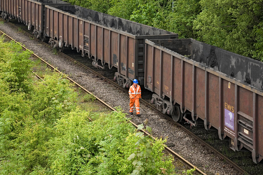 Shunter walking the flyash empties train, site of Calvert station site 
 The shunter walks the length of the MBA box wagons in order to operate the ground frame so that it can leave. It will follow the GCR tracks a very short distance and then head a short distance northeast on a sharp curve towards Winslow. The shunter will then detach the 56 and it will run round the wagons to then head southwest back to Didcot via Bicester and Oxford. On arrival at Didcot, it will enter the power station complex, be loaded with more flyash and do the whole thing all over again! 
 Keywords: Shunter walking the flyash empties train site of Calvert station site