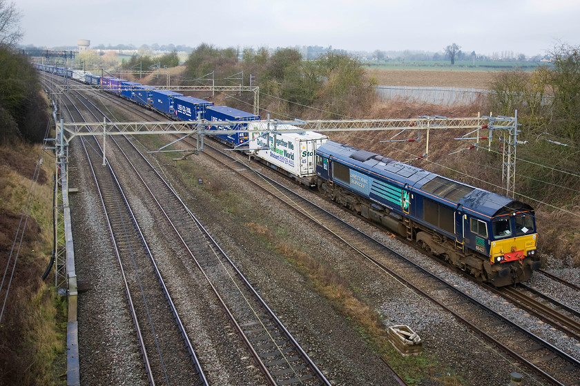 66427, 12.09 DIRFT-Purfleet (4L98), Victoria bridge 
 A 100% regular Sunday freight working past Roade is the Daventry (DIRFT) to Purfleet or London Gateway freightliner working. The time that this leaves Daventry varies considerably but it still carries the same reporting number of 4L98. It is seen passing Victoria bridge between Northampton and Milton Keynes with DRS' 66427 leading. 
 Keywords: 66427, 12.09 DIRFT-Purfleet (4L98), Victoria bridge