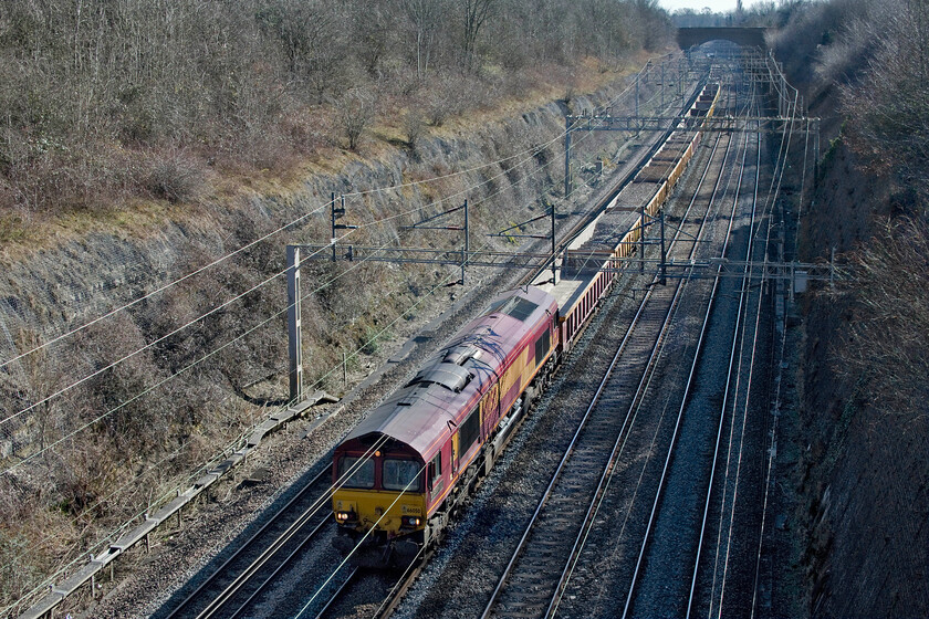 66050, 11.22 King's Langley-Crewe Basford Hall (7R02, 5L), Roade cutting 
 I had been monitoring the progress of the 7R02 11.22 King's Langley to Crewe Basford Hall engineering train for some time but it suddenly disappeared from RTT and OTT without a trace! I was about to give up and go home when it suddenly reappeared having obviously gone off route at Bletchley to then get going again towards Milton Keynes. I had a pleasant wait above Roade cutting while it headed north towards me seen here with 66050 'EWS Energy' leading. This locomotive really is a 'blast from the past' being still in EWS livery complete with all branding and even carrying an EWS pair of nameplates back from the days when it would have been hauling all manner of coal trains around the country - remember those times? 
 Keywords: 66050 11.22 King's Langley-Crewe Basford Hall 7R02 Roade cutting