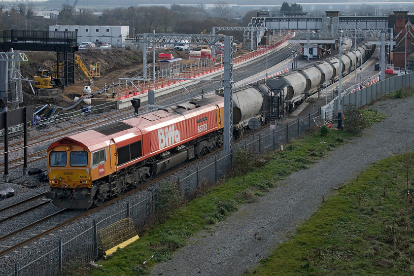 66783, 11.06 Churchyard-Ketton (6F93, 2L), Driver Way bridge 
 This is my first photograph taken from the recently opened Driver Way bridge just north of Wellingborough station. It affords impressive and more intimate views of Wellingborough station rather than from Mill Road bridge that is located a short distance behind me. In this view, the works to install the electrification equipment, the new platform four and the second relief line can be clearly seen. GB Railfreight, operated by Biffa branded 66783 'The Flying Dustman' (formerly EWS 66058), leads the 11.06 Churchyard (St. Pancras) to Ketton empty cement wagons working. The return working takes large volumes of cement right into central London to satisfy its insatiable building requirement needs including projects such as Crossrail and HS2 of course! 
 Keywords: 66783 11.06 Churchyard-Ketton 6F93 Driver Way bridge The Flying Dustman cement train Biffa GB Railfreight