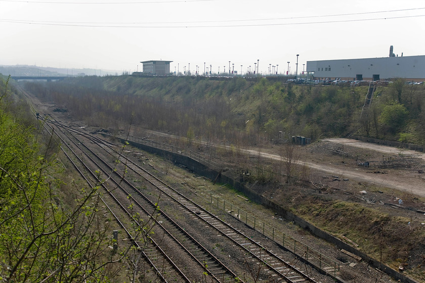 Former Tinsley Yard 
 Looking south-east from Wood Lane bridge the remains of the once-mighty Tinsley yard are seen. Opened in 1965 by Sir Richard Beeching it was heralded as the future of freight on the railways being designated as a 'network yard' but in truth, it was already redundant as the rail freight that it was designed for was in terminal decline. In this scene the site of the former signal box can be seen once located on the slab of concrete to the far right of the image. Unfortunately, it was destroyed by arsonists in 2010 a few months after it was finally closed. The steps rising up the bank to the far right of the image led up to the former Tinsley depot (TI from 1973) that was located where the warehouse is now constructed. Like the marshalling yard, the depot had a ridiculously short working life opening in 1965 and closing in 1998. In its final year of operation it was owned by EWS and used for the storage of redundant and withdrawn diesels. 
 Keywords: Former Tinsley Yard