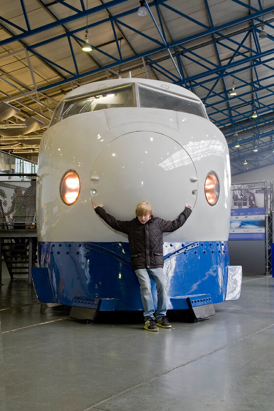 22.141, on display, NRM 
 Shinkansen (Eng. new trunk line) leading car number 22-141 from one of Japan's fabled 'bullet trains is seen on display inside the great hall at the NRM. It was built by West Japan Railways entering service in 1976 being withdrawn from service in October 2000. Initially, it operated between Tokyo and Osaka as part of a sixteen-car formation. However, in its golden years from 1987, it operated as a four-car set between Hiroshima and Hakarta. It was comprehensively restored by the staff of JR West before it was donated to the NRM where it went on display on 2002. 
 Keywords: 22.141 on display NRM bullet train Shinkansen