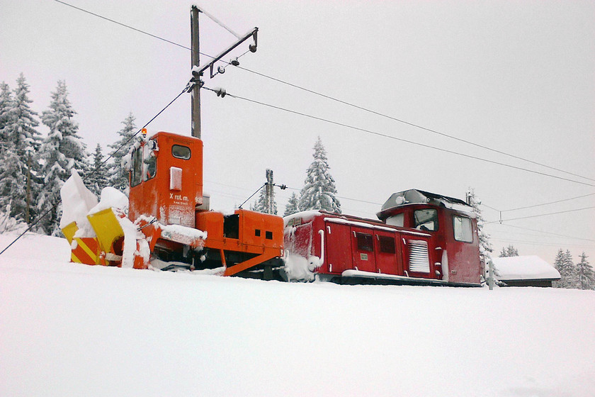 Snow clearance, Col-de-Voza station 
 With the staff of the Mont Blanc Tramway having cleared the line up from Saint-Gervais-Le Fayet as far as here at Col-de-Voza, they set to work getting the rest of the line open up to the summit at 7,782 feet making it Europe's fourth highest mountain railway. Here a diesel unit and snow blower are in use on the 1metre track. Their efforts will have been in vain as there was steady snow all day followed by about a foot of snow falling at resort level the coming night! 
 Keywords: Snow clearance Col-de-Voza station