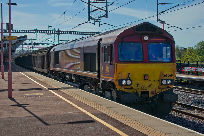 66060, 01.04 Dollands Moor-Ditton (6M13, 15E), Rugby station 
 A vert tatty looking 66060 passes through Rugby station at some speed with the 6M13 01.04 Dollands Moor to Ditton cargo vans. Despite passing my home location some fifteen miles or so to the south this is a service that I have few photographs of as it passes in the early hours then taking a stopover at Daventry where the consist is remarshalled before continuing north at a far more sociable hour! Notice that 66060 still wears the 'Three Beasts' logo under the cab window but that it has lost its EWS branding the complete opposite of the many of the other remaining DB painted Class 66s. 
 Keywords: 66060 01.04 Dollands Moor-Ditton 6M13 Rugby station EWS