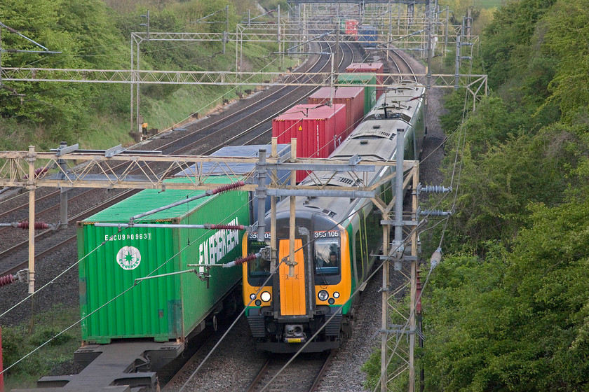 350105, LM 07.05 Northampton-London Euston (2N04, 6L) & 03.15 Felixstowe North-Trafford Park (4M21), Victoria Bridge 
 350105 forms the 07.05 Northampton to Euston working past Victoria Bridge just south of Roade. It is passing the 03.15 Felixstowe to Trafford Park Freightliner. Despite it being late April, the early morning dull light was poor and I was pushing the camera's ISO capabilities somewhat! It's testament to modern camera technology that a decent picture can be taken in these conditions with such a little amount of digital 'noise'. 
 Keywords: 350105 2N04 4M21 Victoria Bridge