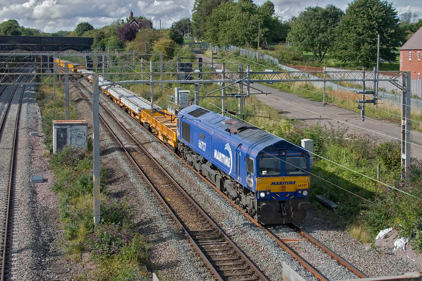 66727, 14.07 Bescot Yard-Wolverton (via Wembley) (6G57, 48L), site of Roade station 
 The final of five infrastructure trains passing south past Roade on this Saturday afternoon led by 66727 'Maritime One'. Like all of the others that I photographed, they started out from Bescot and were heading for Wolverton via a lengthy extra leg to Wembley and back. I have photographed 66727 a number of times in my home area and the majority of times it has been on engineering trains such as this. 
 Keywords: 66727 14.07 Bescot Yard-Wolverton via Wembley 6G57 site of Roade station GBRf Maritime One