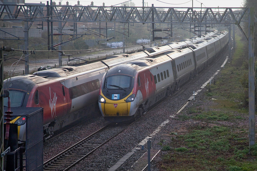 390129, VT 08.30 Birmingham New Street-London Euston (1B08, 4E) & 390039, VT 08.40 London Euston-Manchester Piccadilly (1H36, RT), site of Roade station 
 A passing of Virgin services at the site of the former station at Roade in Northamptonshire. To the left, 390129 'City of Stoke-on-Trent' heads south with the 08.30 Birmingham New Street to Euston 1B08 service. To the right, proudly wearing its Coventry flag on the cab front, 390039 'Lady Godiva' passes northwards with the 08.40 Euston to Manchester Piccadilly. The latter was named at Coventry station in April 2019 and is part of the promotion campaign for Coventry's City of Culture status during 2021. 
 Keywords: 390129 08.30 Birmingham New Street-London Euston 1B08 390039 08.40 London Euston-Manchester Piccadilly 1H36 site of Roade station Pendolino Virgin Trains Lady Godiva