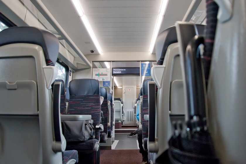 Interior 755327, 09.44 Sheringham-Norwich (2S09, RT) 
 The interior of 755327 working the 09.44 Sheringham to Norwich service. The seats were comfortable and not as hard as some others fitted to recent new trains. The interior was light and airy with excellent information screens and automated announcements but was a long message from the guard also needed which was merely doubling up and possibly leading to information overload - one or the other, please! The main feature of these trains was their eerie silence! Unlike all other units with diesel engines over recent years, these three or four-car units do not have underslung engines but rely on a what is referred to 'power pack vehicle' containing two (two-car) or four (four-car) Deutz V8 16 litre diesel engines. An unusual design feature is the passenger corridor through this motor vehicle but when the train is in motion and under load it is a noisy and hot place to pass through. The other strange thing that my wife noted was the low slung seating position of the main passenger cabin. This was obviously permitted by the absence of underfloor engines but also permits step-free access at all stations. 
 Keywords: Interior 755327, 09.44 Sheringham-Norwich 2S09