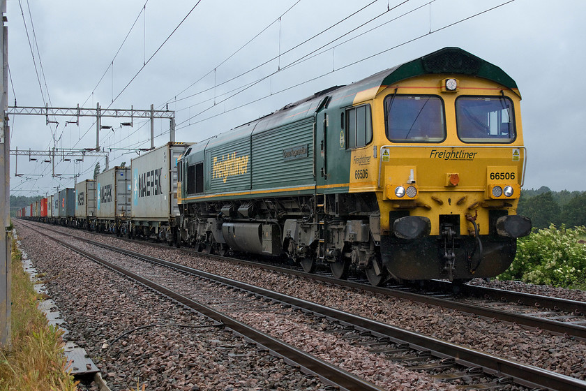 66506, 08.25 Crewe Basford Hall-Felixstowe North (4L93), Wilson`s Crossing 
 In weather more reminiscent of November than flaming June, 66506 'Crewe Regeneration' passes Wilson's crossing to the north of Northampton with the 4L93 08.25 Crewe Basford Hall to Felixstowe Freightliner. I stood at this spot wearing, jeans, boots, two top layers, and my GORE-TEX jacket to protect myself from the wind and rain! 
 Keywords: 66506 08.25 Crewe Basford Hall-Felixstowe North 4L93 Wilson`s Crossing