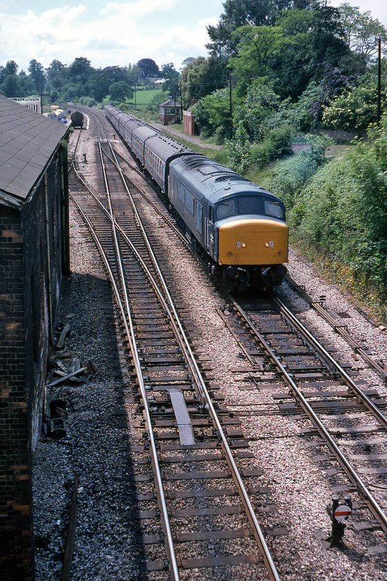 46032, 10.00 Newquay-Sheffield (1E22), Wellington 
 46032 will be rattling over the pointwork at Wellington as it descends from Whiteball summit leading the 1E22 10.00 Newquay to Sheffield. To the left in this photograph is the former goods shed with the former station platforms (closed 05.10.64) still extant. On the former up platform is the superb signal box that still permitted access to the down station loop and controlled the crossover under the locomotive. The box was the block post between Silk Mill (east) and Whiteball (west) a relatively long section with the eastern section of Whiteball bank in between. 
 Keywords: 46032 10.00 Newquay-Sheffield 1E22 Wellington