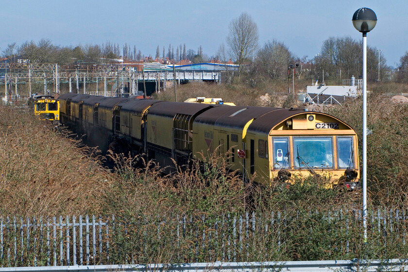 DR792417 & track maintenance stock, Northampton Yard 
 A rake of rail grinders are seen lined up in the somewhat overgrown backyard at Northampton. I am standing on the upper deck of the new multi-storey car park monstrosity! 
 Keywords: DR792417 track maintenance stock Northampton Yard