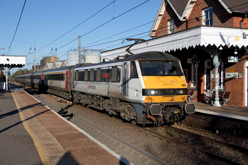 90011, 15.30 Norwich-London Liverpool Street (1P49, RT), Diss station 
 Seen earlier at Norwich, 90011 'East Anglia Daily Times: Suffolk & Proud' slows with the 15.30 Norwich to London Liverpool Street for its stop at Diss station. The weather brought beautiful and crisp autumn air that is a joy to take pictures in, with a nice low sun angle that ensures that the subject is clearly lit. 
 Keywords: 90011 15.30 Norwich-London Liverpool Street 1P49 Diss station