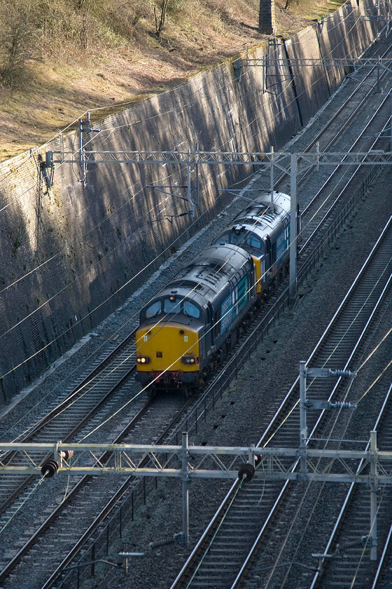 37609 & 37610, London Waterloo-Derby route learner (0Z39), Roade cutting 
 37609 leads 37610 'TS (Ted) Cassady 14.5.61-6.4.08' through Roade cutting but just missing the rays of the afternoon sun that are dappling the retaining wall. The pair of vintage English Electric locomotives were working the 0Z39 Waterloo to Derby route learning train. Close examination of the photograph reveals at least three occupants in the leading cab getting their route knowledge up to date. 
 Keywords: 37609 37610 London Waterloo-Derby route learner 0Z39 Roade cutting DRS Direct Rail Services TS (Ted) Cassady 14.5.61-6.4.08