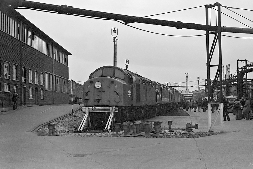 40076, 40044 & 40151, Crewe Works 
 In the gathering gloom of a cold February afternoon, a trio of Class 40s are seen outside at Crewe works. First in the line-up is 40076 that came on the works in September 1978 following a cubicle fire that damaged the main generator, it left in April 1979. In the middle of the line-up is 40044 with much damage to number two end. It had come to grief at Chinley on 31.08.78 being unable to stop after being put into a loop. Repairs were authorised and it returned to traffic 07.01.80. Finally in the line-up is 40151 that was to receive crankshaft repairs. Its stay was relatively short being back in service by the beginning of March. Notice the randomly deposited buffers in the foreground. 
 Keywords: 40076 40044 40151 Crewe Works