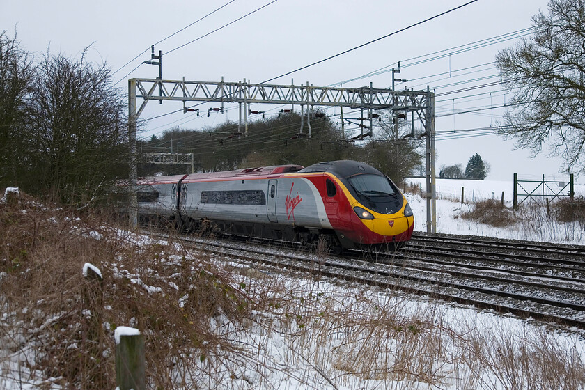 390121, VT 10.00 London Euston-Manchester Piccadilly, Roade 
 Taking photographs whilst on crutches in a field and in the snow was quite a challenge! Not the finest photograph of a Pendolino but given the circumstances mentioned then it will have to do! 390121 approaches Roade working the 10.00 Euston to Manchester service. 
 Keywords: 390121 10.00 London Euston-Manchester Piccadilly Roade VWC Virgin Pendolino