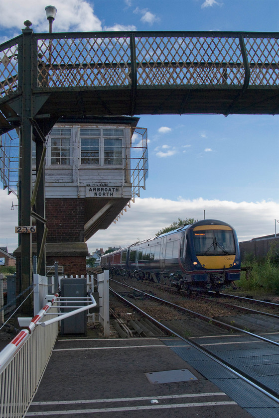 170409, SR 14.41 Glasgow Queen Street-Inverness (1A69), Arbroath Wellgate level crossing 
 This angle really shows off the design of Arbroath North signal box with aplomb! It is the only example of a signal cabin oversailing the base on the Scottish network meaning that it and the footbridge spanning the line at Wallgate level crossing are listed structures by Historic Environment Scotland. The box and crossing is about to be passed by 170409 working the 14.41 Glasgow Queen Street to Inverness that goes via Aberdeen rather than the more direct Perth and Avimoore route. 
 Keywords: 170409 14.41 Glasgow Queen Street-Inverness 1A69 Arbroath Wellgate level crossing ScotRail Arbroath North signal box