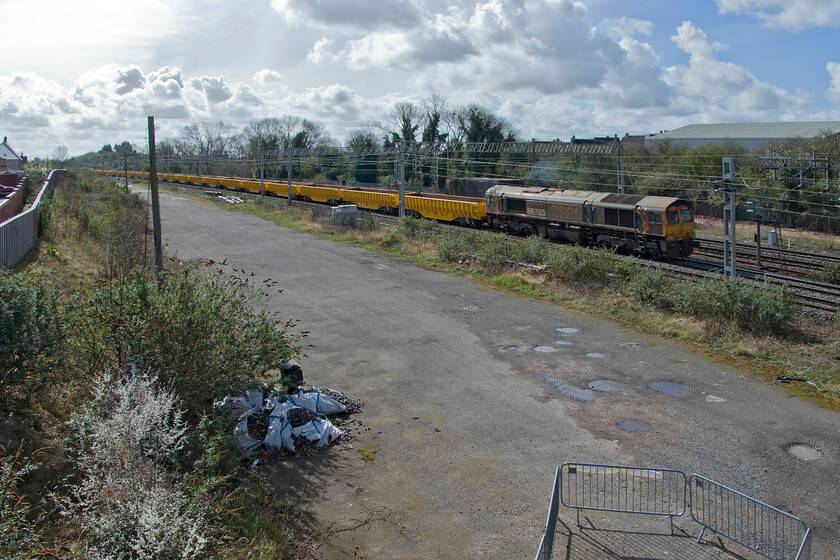 66754, engineering train in possession, site of Roade station 
 Working outside at home a short distance from the line in Roade I had been aware of the sound of an idling Class 66 for some time. I ventured out on my bike with my camera over my shoulder to investigate. Having taken the rear of the train (previous image) I nipped to the site of Roade's former station to see the front end. I timed it just right as the train started to move off as I got off my bike. 66754 'Northampton Saints' is seen creeping along leading an engineering train heading for its worksite at the nearby Sergo Logistics Park that is to be rail connected at both the north and south ends. 
 Keywords: 66754 engineering train in possession, site of Roade station Northampton Saints