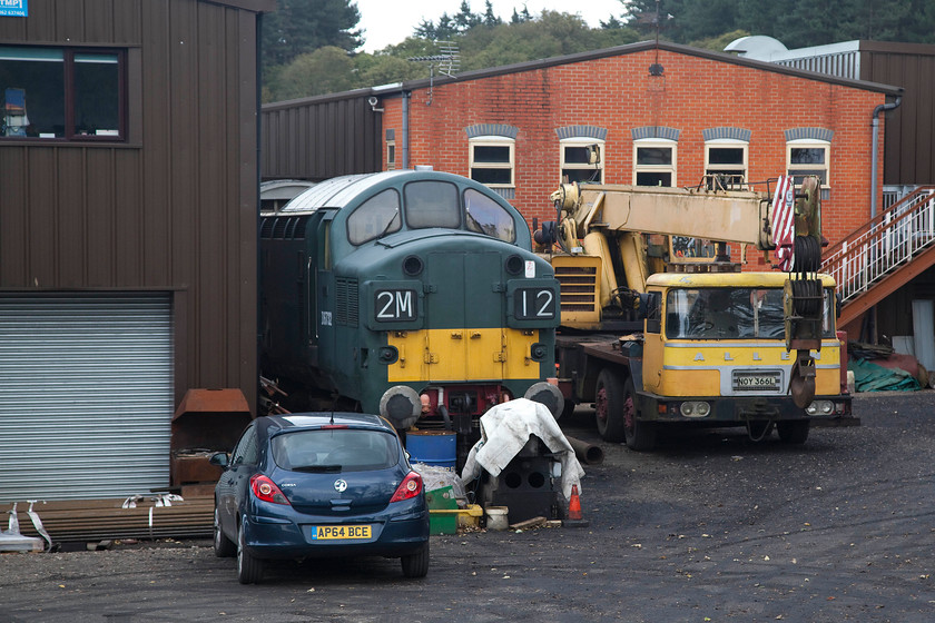 D6372 (37032), undergoing overhaul, Weybourne Depot 
 Looking a bit sorry for itself, D6372 (37032) pokes its nose around the corner of Weybourne's depot. The 37 is undergoing an extensive and protracted overhaul. Built at Newton-Le-Willows in 1962, it saw many years of successful service it was withdrawn as 37353 in March 1994. 
 Keywords: D6372 37032 undergoing overhaul Weybourne Depot