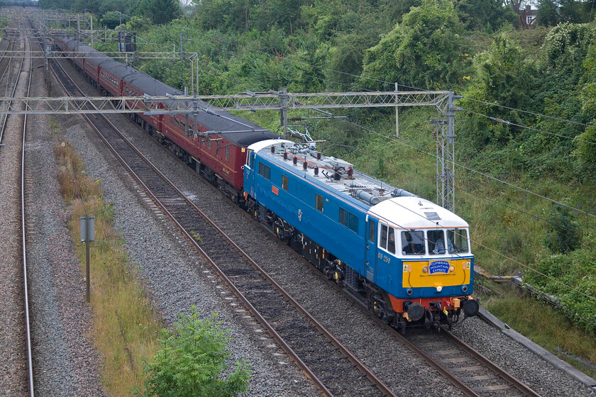 86259, outward leg of The Cumbrian Mountain Express, 06.42 London Euston-Carlisle (1Z86, 1E), Victoria bridge 
 The outward leg of The Cumbrian Mountain Express passes Victoria bridge a short distance south of Roade led, as usual, by 86259 'Les Ross/Peter Pan'. On arrival at Carnforth, Black 5 44871 would take over the train to lead it north over Shap to Carlisle. 
 Keywords: 86259 The Cumbrian Mountain Express 06.42 London Euston-Carlisle 1Z86 Victoria bridge Les Ross Peter Pan