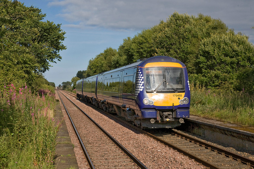 170450, SR 15.24 Inverurie-Edinburgh Waverley (1B40), Barry Links station 
 170450 passes Barry Links station working the 15.24 Inverurie to Edinburgh Wavery ScotRail train. It is passing the station without stopping as do most trains making Barry Links Scotland's least used station with only one train stopping in each direction (two in total) per day. I am standing on the platform end where it is fenced off with the remains of the now unused platform extensions still in place. 
 Keywords: 170450 15.24 Inverurie-Edinburgh Waverley 1B40 Barry Links station ScotRail