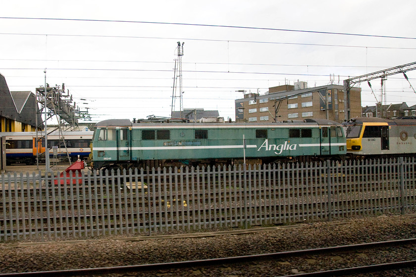 86246 & 92043, stabled, Willesden MPD 
 Looking a bit sad wearing its very faded Anglia livery that was once described as being Turquoise Green 86246, formally 'Royal Anglian Regiment' sits at Willesden depot with 92043 'Debussey'. The 86 had been rescued from storage at Long Marston by Europhoenix being selected for future use abroad. 
 Keywords: 86246 92043 stabled Willesden MPD