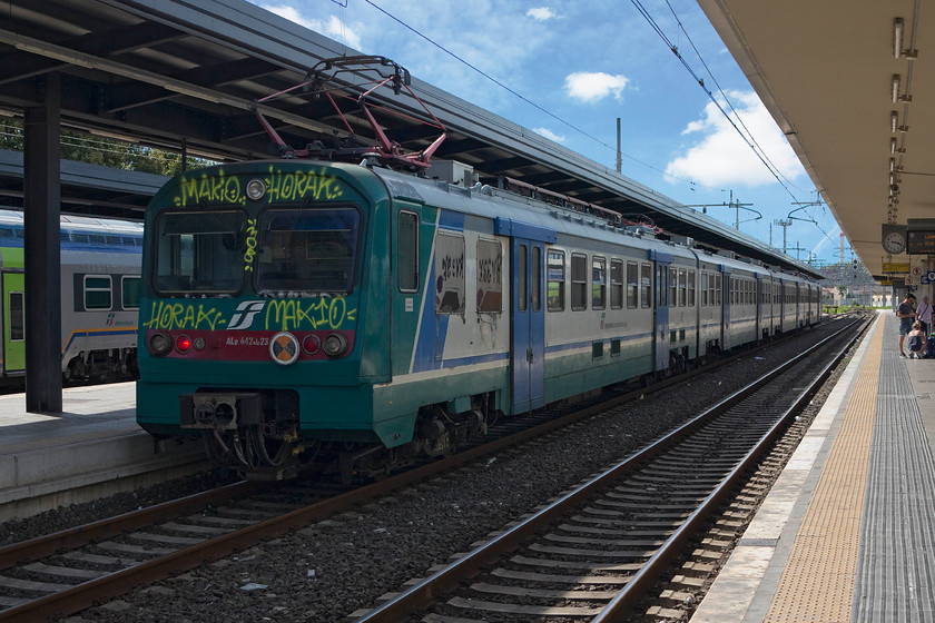 642.023, stabled, Pisa Central station 
 A feature of many Italian trains and infrastructure is the work of the graffiti vandals. EMU 642.023 stands stabled at Pisa Central station. the class 642 number about sixty units that were built by Ansaldo-Breda (now part of Hitachi) in the early 1990s. 
 Keywords: 642.023 stabled Pisa Central station