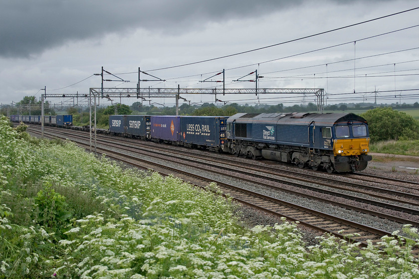 66434, 13.09 DIRFT-Ripple Lane (4L48, RT), Gordon`s Lodge 
 66434 works its way along the up slow line leading the 4L48 13.09 Daventry to Ripple Lane past Gordon's Lodge a short distance north of Hanslope Junction. Note the particularly dark and menacing cloud approaching from the north that did what you would expect it to do in the next ten minutes; good job I was wearing my GORE-TEX jacket! 
 Keywords: 66434 13.09 DIRFT-Ripple Lane 4L48 Gordon`s Lodge Tesco DRS Direct Rail Services