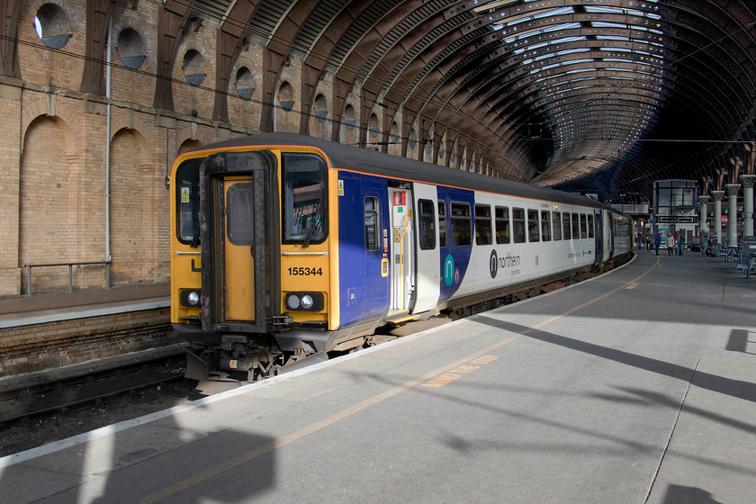 155334, NT 10.50 York-Hull (2R94, 4E), York station 
 The curve of the train matches the curvature of York's fine roof in this photograph. 153334 was attached to a Pacer and the pair are seen about to leave the station with the 2R49 10.50 to Hull. It is scenes like this that make York one of my favourite stations for taking pictures in being architecturally dramatic, varied and full of interest. 
 Keywords: 155334 10.50 York-Hull 2R94 York station Northern service