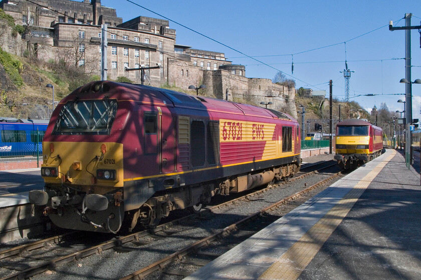 67021 & 90028, stabled, Edinburgh Waverley station 
 A couple of EWS beauties basking in the spring sunshine at the eastern end of Edinburgh Waverley station! I am open to correction on this but I think that 67021 to the left was acting as a Thunderbird ready to rescue any trains that got into trouble on the double-track ECML south of Edinburgh. 90028 will have worked the previous night's down Caledonian Sleeper service from Euston. Tonight it will return south again with the up Highland service once the three portions arrive from Fort William, Inverness and Aberdeen, hopefully, all relatively on time avoiding onward delays! 
 Keywords: 67021 90028 stabled Edinburgh Waverley station EWS