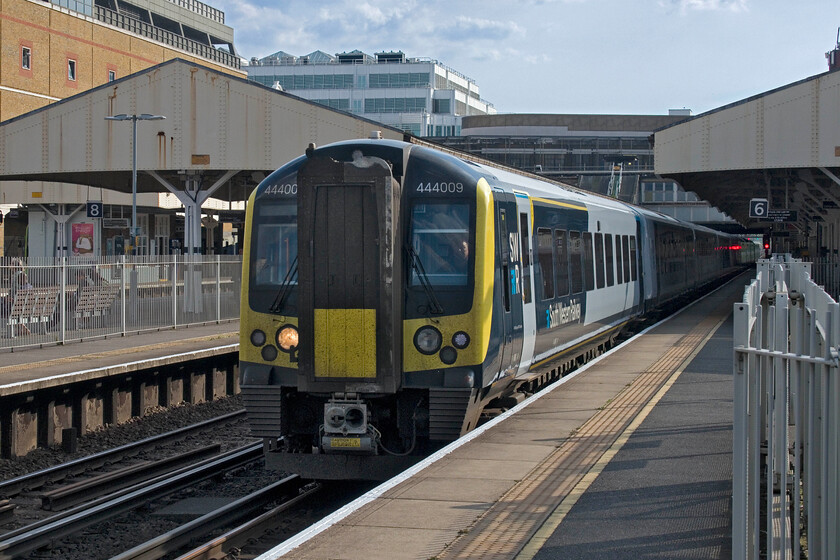 444009, SW 15.17 Portsmouth Harbour-London Waterloo (1T56, RT), Wimbledon station 
 I have never been to Wimbledon station and was surprised to find that platforms six and seven were fenced off with sliding gates opened when a stopping train used these platforms. Designated as the fast lines trains did speed through pretty regularly even for a Sunday afternoon so I suppose H&S won on this one! 444009 passes working the 15.17 Portsmouth Harbor to Waterloo service where it would arrive in about fifteen minutes. 
 Keywords: 444009 15.17 Portsmouth Harbour-London Waterloo 1T56 Wimbledon station SWT South Western Railway